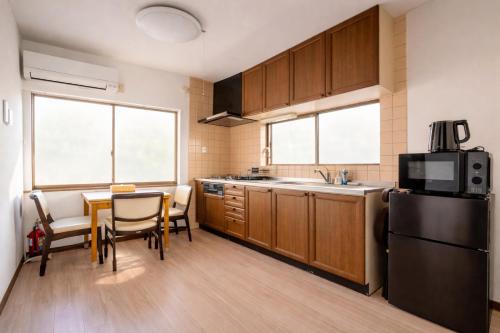 a kitchen with a table and a black refrigerator at 狐狐 Coco in Kyōto