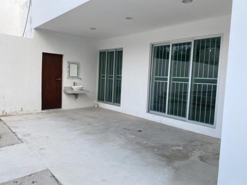 an empty white room with a sink and windows at Minimalist house with pool and patio in Chicxulub