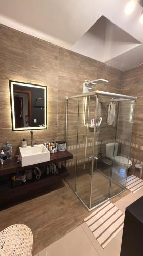 a bathroom with a glass shower and a sink at Cozy house with pool in Campo Grande