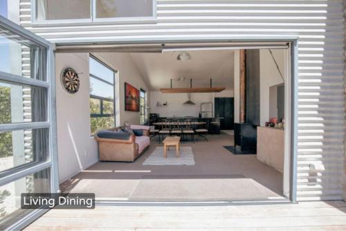 a living room and dining room with a sliding glass door at Spacious Mt Hutt Ski & Summer Lodge in Methven with Spa in Methven