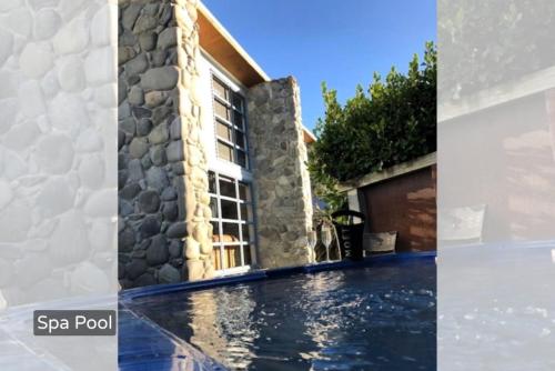 a villa with a swimming pool and a house at Spacious Mt Hutt Ski & Summer Lodge in Methven with Spa in Methven