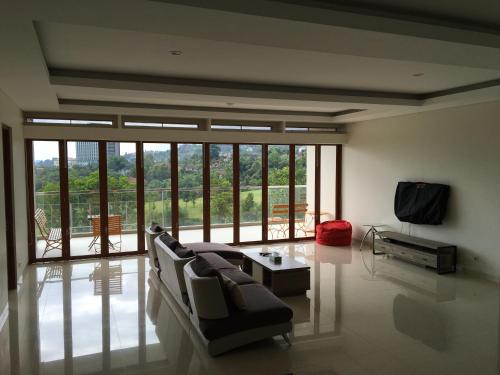 a living room with a couch and a tv at Roemah Asri Villa - Resor Dago Pakar in Bandung