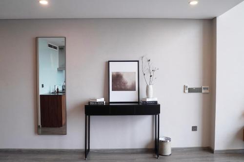 a mirror and a table with a picture on it at PentStudio Westlake - Cozy Duplex - New Apartment in Hanoi