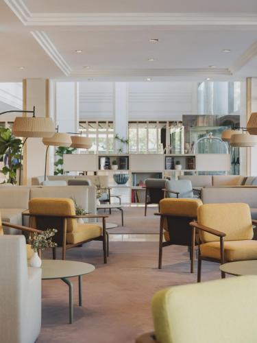 a waiting room with chairs and tables and lamps at Meliá Sitges in Sitges