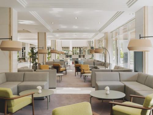 a waiting room with couches and tables and chairs at Meliá Sitges in Sitges