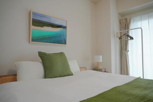 a bedroom with a large white bed and a window at INA HOUSE Miyakojima 302 in Miyakojima