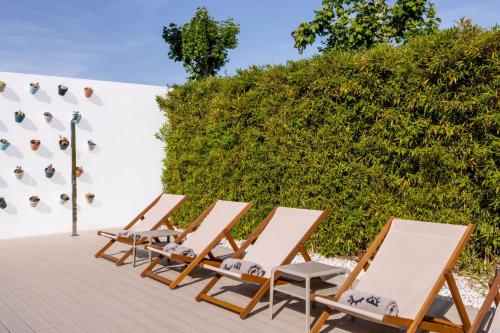 a row of deck chairs sitting next to a wall at INNSiDE by Meliá Barcelona Aeropuerto in El Prat de Llobregat