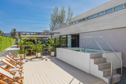 a house with a swimming pool and some chairs at INNSiDE by Meliá Barcelona Aeropuerto in El Prat de Llobregat