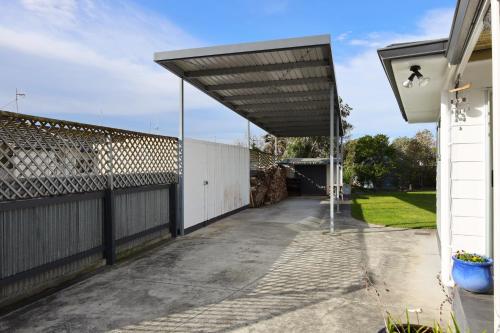 a garage with awning on the side of a house at Rev it up Homestay in Feilding