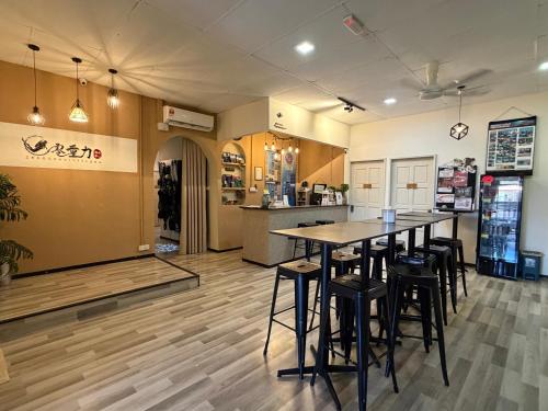 a restaurant with tables and stools in a room at Zero Gravity Homestay 零重力民宿 in Semporna