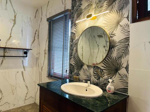 a bathroom with a sink and a mirror at Ploythai Villa 2 in Haad Pleayleam