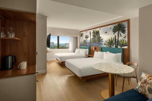 a hotel room with a bed and a table at Courtyard by Marriott Darwin in Darwin