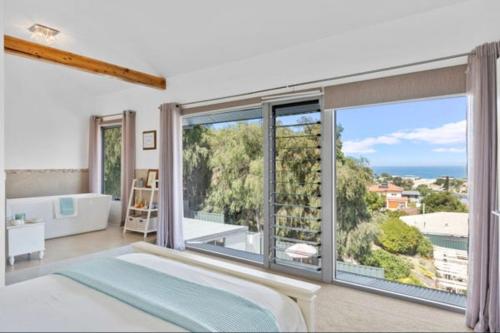 a bedroom with a large window with a view of the ocean at Quinns Oasis in Quinns Rocks