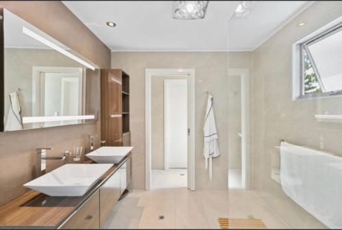 a bathroom with two sinks and a large mirror at Quinns Oasis in Quinns Rocks