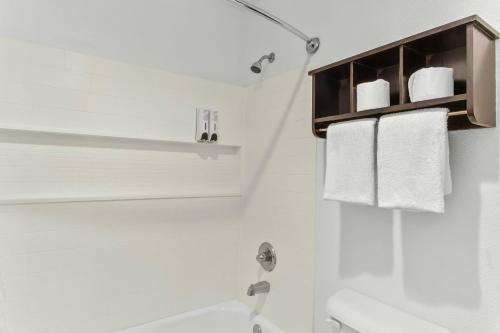 a bathroom with a sink and a shower with towels at Red Roof Inn Houston - Jersey Village in Houston