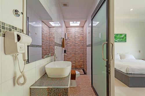 a bathroom with a sink and a shower and a bed at Natai House Resort นาใต้เฮ้าส์ รีสอร์ท in Natai Beach
