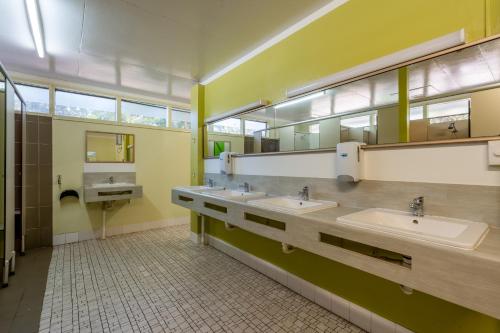 a bathroom with three sinks and two mirrors at BIG4 Tasman Holiday Parks - Nambucca Heads in Nambucca Heads