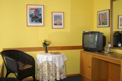 ライネにあるHotel Borcharding Rheine Mesumの小さなテーブルとテレビが備わる客室です。