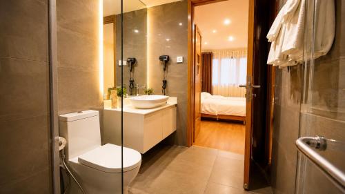 a bathroom with a toilet and a sink and a mirror at Axis Residences Apartment in Phnom Penh