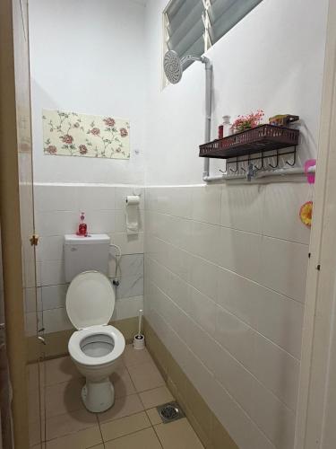 a bathroom with a white toilet in a room at Laman D'Manees in Kampung Bukit