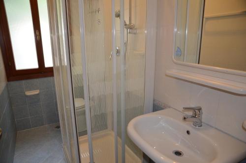 a bathroom with a sink and a glass shower at Appartamenti Villa Frediana in Bibione