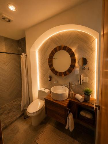 a bathroom with a sink and a toilet and a mirror at Hotel Boutique Sol y Luna SPA in Ajijic