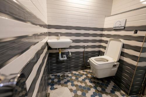 a bathroom with a toilet and a sink at Omji Ashram - Ramnagar 10 min from Shri Banke Bihari Temple in Vrindāvan