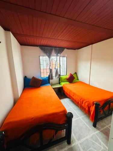two beds in a room with orange and blue at Nuevo Hotel Transportador in Bogotá
