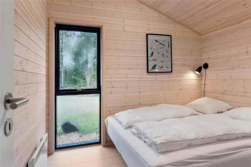 a bedroom with a bed in a room with a window at 0410-Romo-Strandskaden-15 in Høm