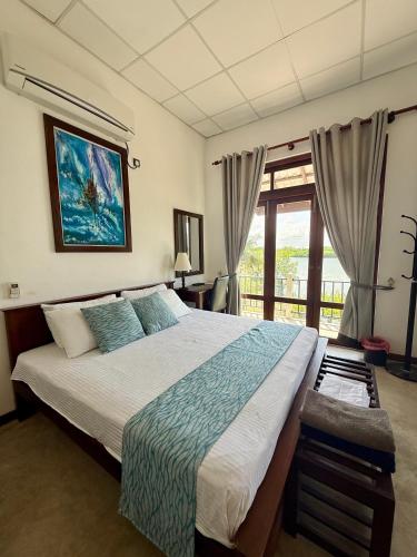 a bedroom with a large bed and a window at Aurora Lagoon Front in Negombo