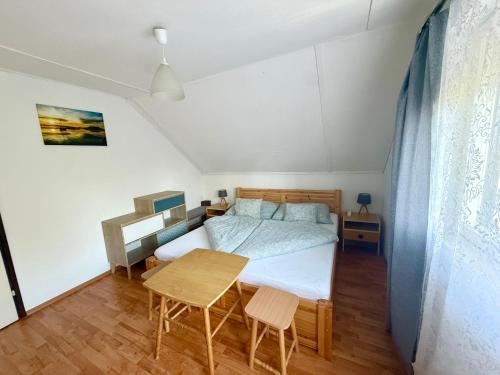 a small bedroom with a bed and a table at Balatonfölvári nyaraló in Balatonföldvár
