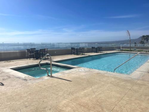 a swimming pool with tables and chairs on a building at Wabi Sabi in Rosarito