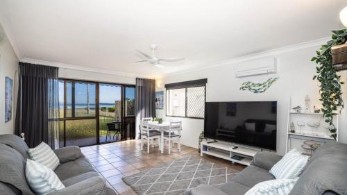 a living room with a couch and a flat screen tv at Great Views, Ground Floor Unit in Bongaree
