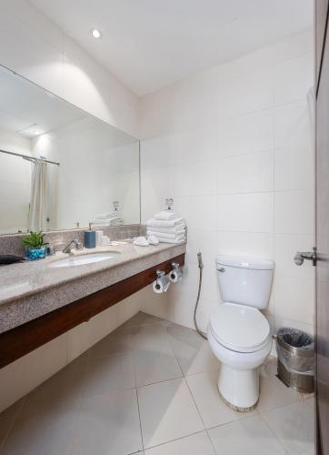 a bathroom with a toilet and a sink and a mirror at Citi Park Hotel Cebu powered by Cocotel in Cebu City