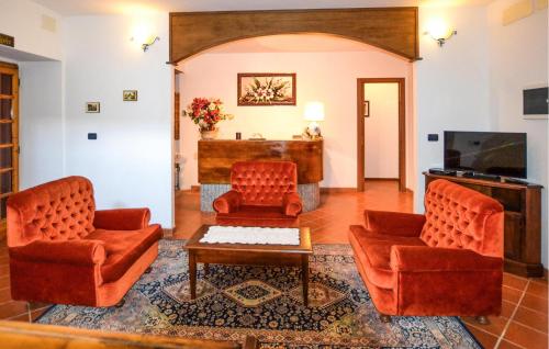 a living room with two chairs and a tv at Oasi Di Cocciola in Badia Tedalda