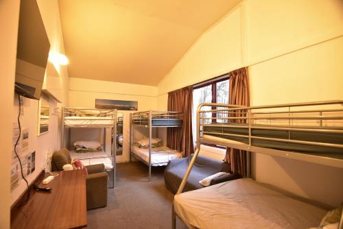a room with two bunk beds and a desk at Stay In Tekapo Backpackers in Lake Tekapo