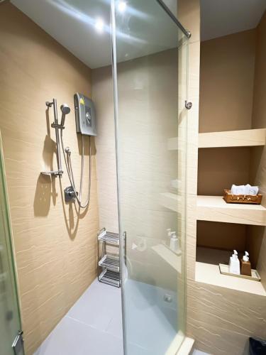 eine Dusche mit Glastür im Badezimmer in der Unterkunft Windmill Resort Hotel Pattaya in Pattaya North
