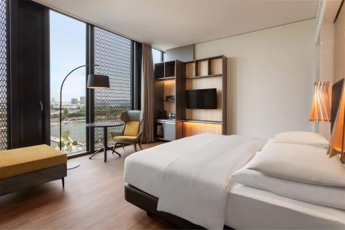 a bedroom with a large bed and a desk with a chair at Meliá Vienna in Vienna