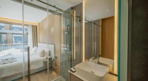 a bathroom with a bed and a sink and a shower at Riverton Hotel in Samut Songkhram