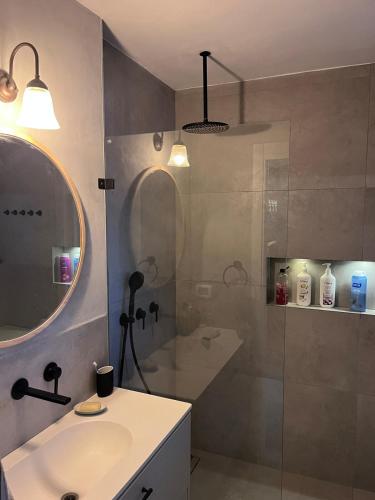 a bathroom with a sink and a shower with a mirror at חלום ליד הנחל in ‘Amir