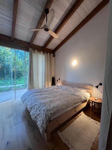 a bedroom with a bed and a ceiling fan at חלום ליד הנחל in ‘Amir