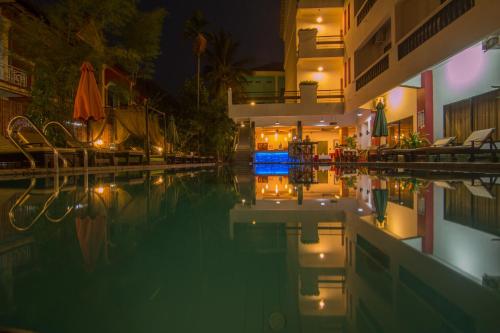 - une piscine avec un hôtel la nuit dans l'établissement Mekong Angkor Palace Hotel, à Siem Reap