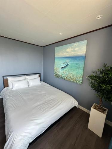a bedroom with a bed and a painting of a boat at Seoungho Kim in Ch'ŏngsap'o