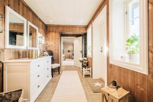 a kitchen with wooden walls and white cabinets at Gamatun cabin in Heimdal