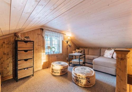 a living room with a couch and two ottoman at Gamatun cabin in Heimdal