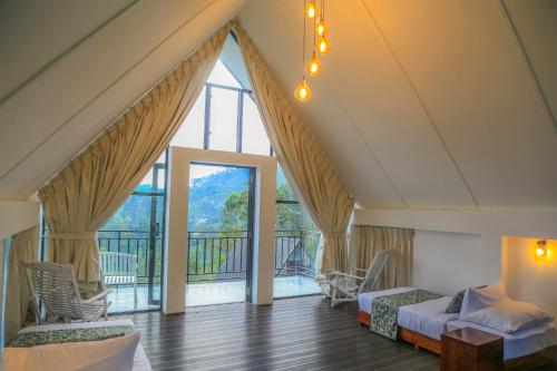 a room with two beds and a large window at Hummingbird St.Clare Villas in Dimbula