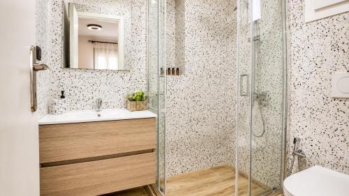 a bathroom with a glass shower and a sink at Elaia & Nyx Residence in Volos