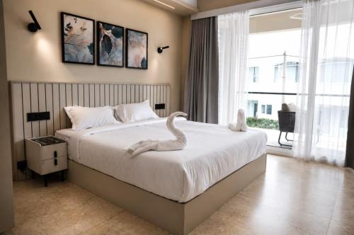 a bedroom with a bed with a swan statue on it at Le Venzia in Sultan Bathery