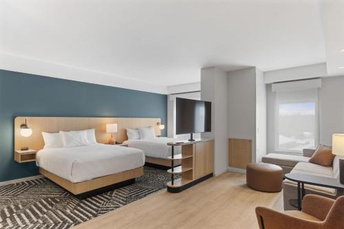 a hotel room with two beds and a flat screen tv at Hyatt House Thunder Bay in Thunder Bay
