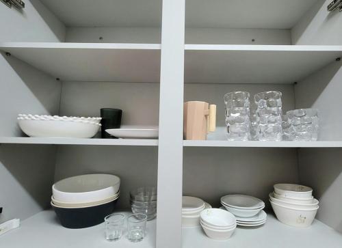 a white shelf with bowls and plates and glasses at Seoungho Kim in Ch'ŏngsap'o